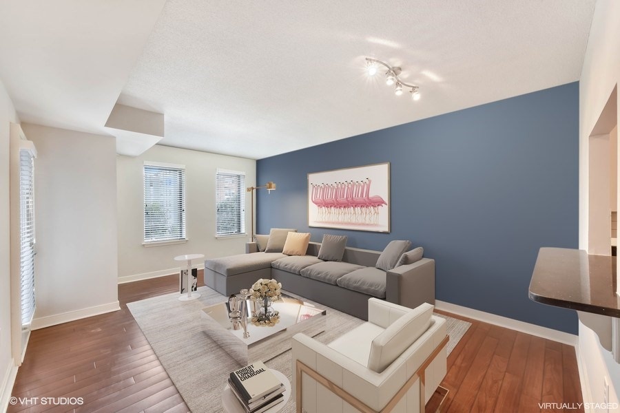 a living room with a blue accent wall and a gray couch